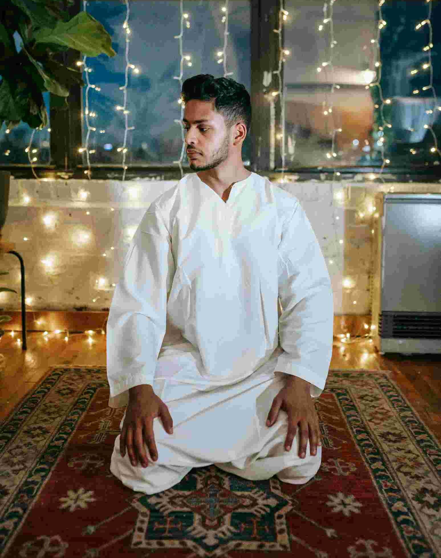 A Muslim sitting in the Tashahud position doing Tasleem during Salah.