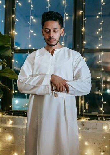 A Muslim standing up in Qiyam with his right hand over the left during salah