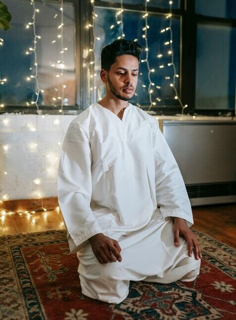 A Muslim sitting in the Tashahud position during Salah.